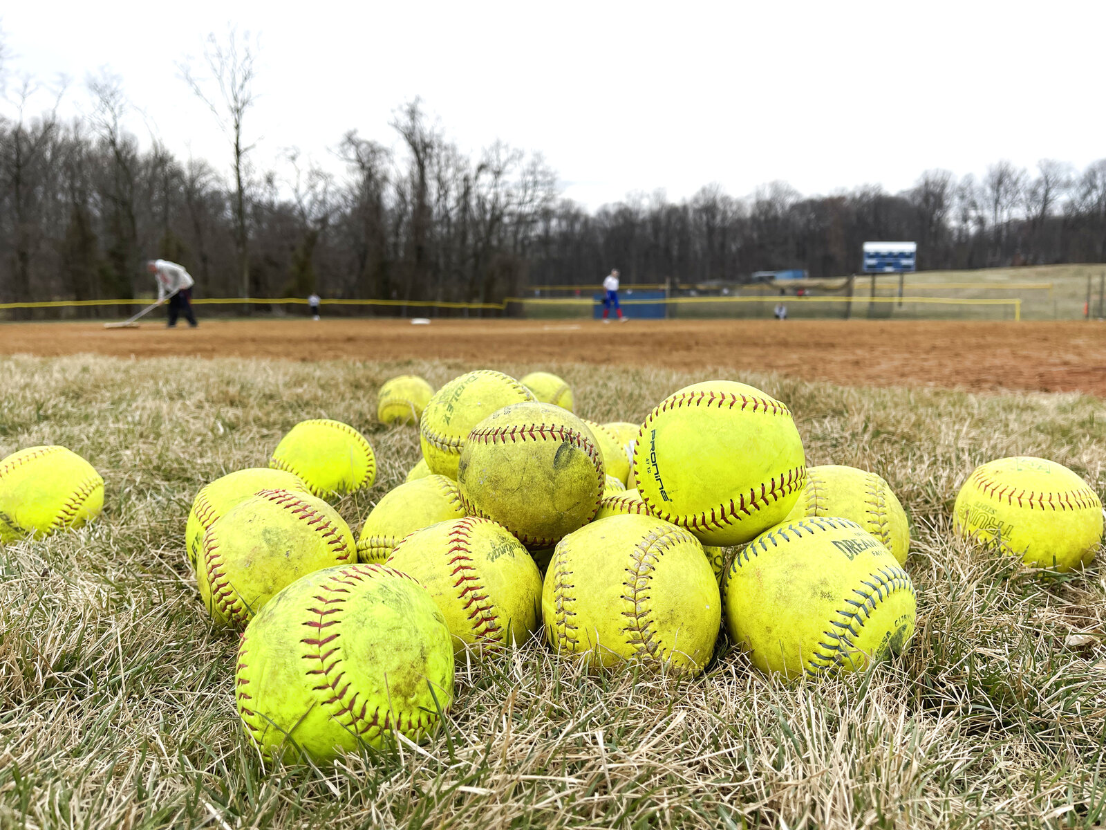 Pile of softballs on the field at dusk