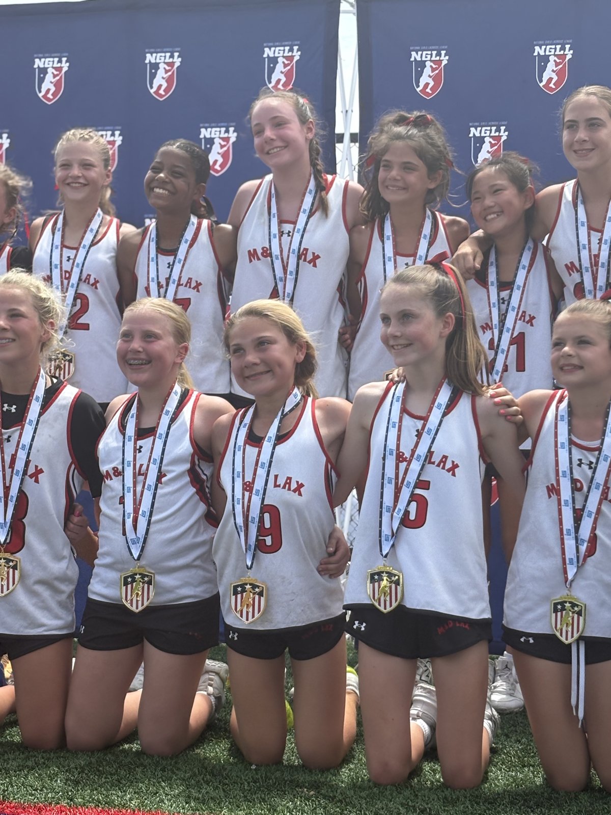 Girls lacrosse team wearing medals after a tournament final
