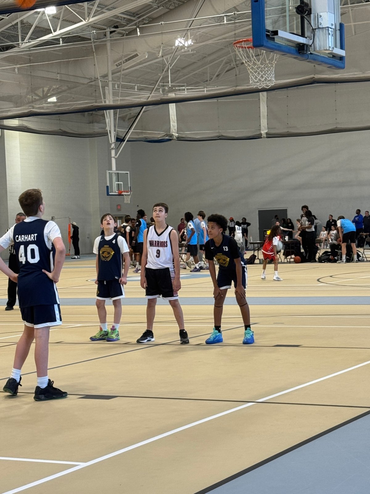 Youth basketball players lined up for a free throw at a tournament