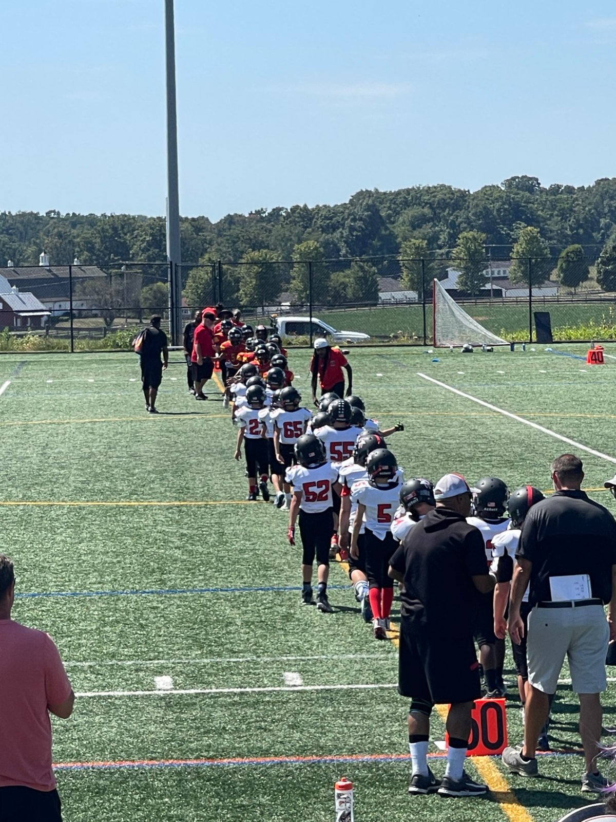 Youth football team lined up along the sideline before a game
